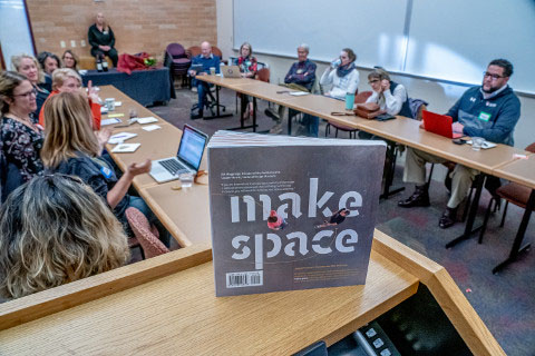 A book titled "Make Space," is propped up on a book shelf.