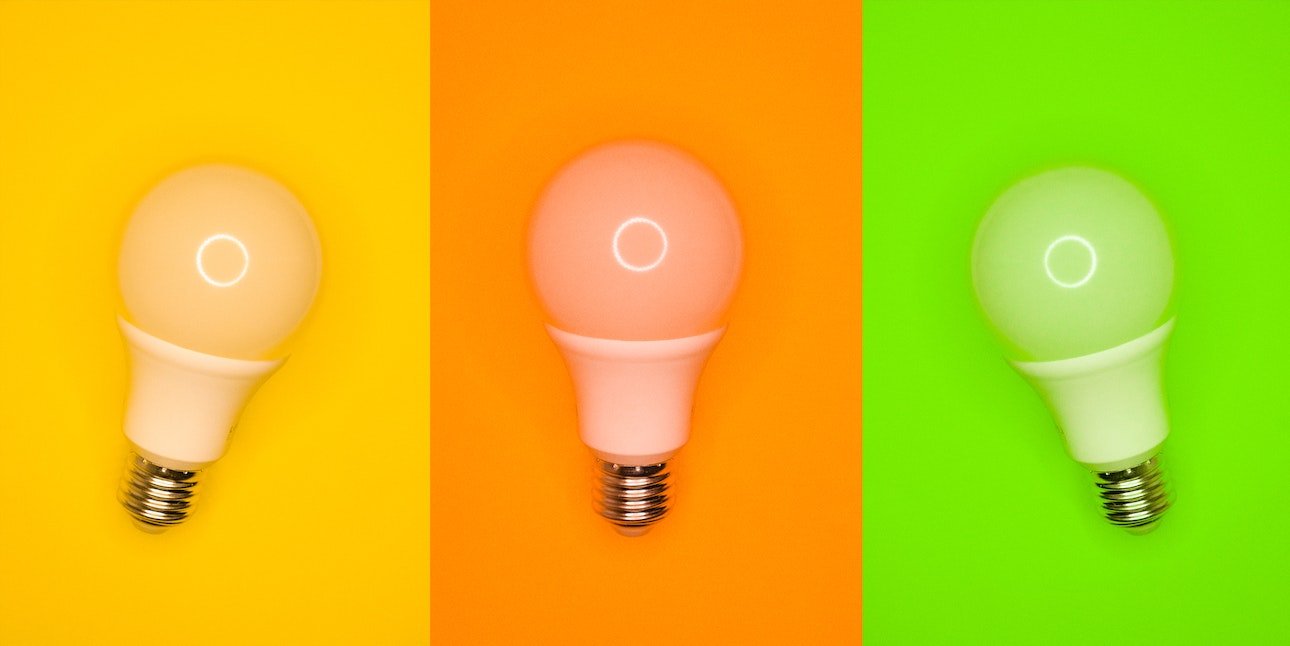 Different colored lightbulbs on colored background
